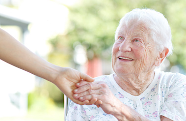 Happy senior woman holding hands with caretaker